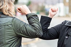 Two people "shaking elbows" instead of hands.